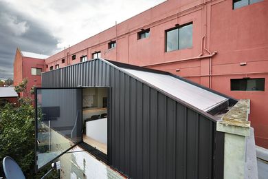 A large pivoting window on the southern wall of this Melbourne terrace opens up to views over rooftops and leafy streets.