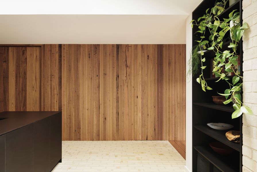 A timber batten wall is threaded through the house, connecting rooms and concealing services.