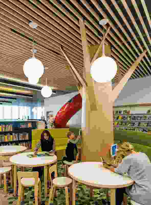 On the first level, the children’s area evokes the concept of a garden with tree-like columns and grass-green rugs.