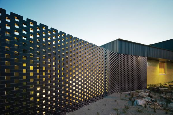 A perforated brick screen shields the northern courtyard from the street.