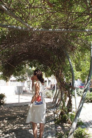 The arched steel pergola, densely woven with vegetation, at Flores & Prats' Fabra and Coats Gardens.