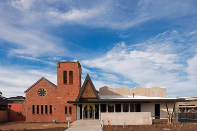 A new concrete wing has been grafted onto the original red brick church.