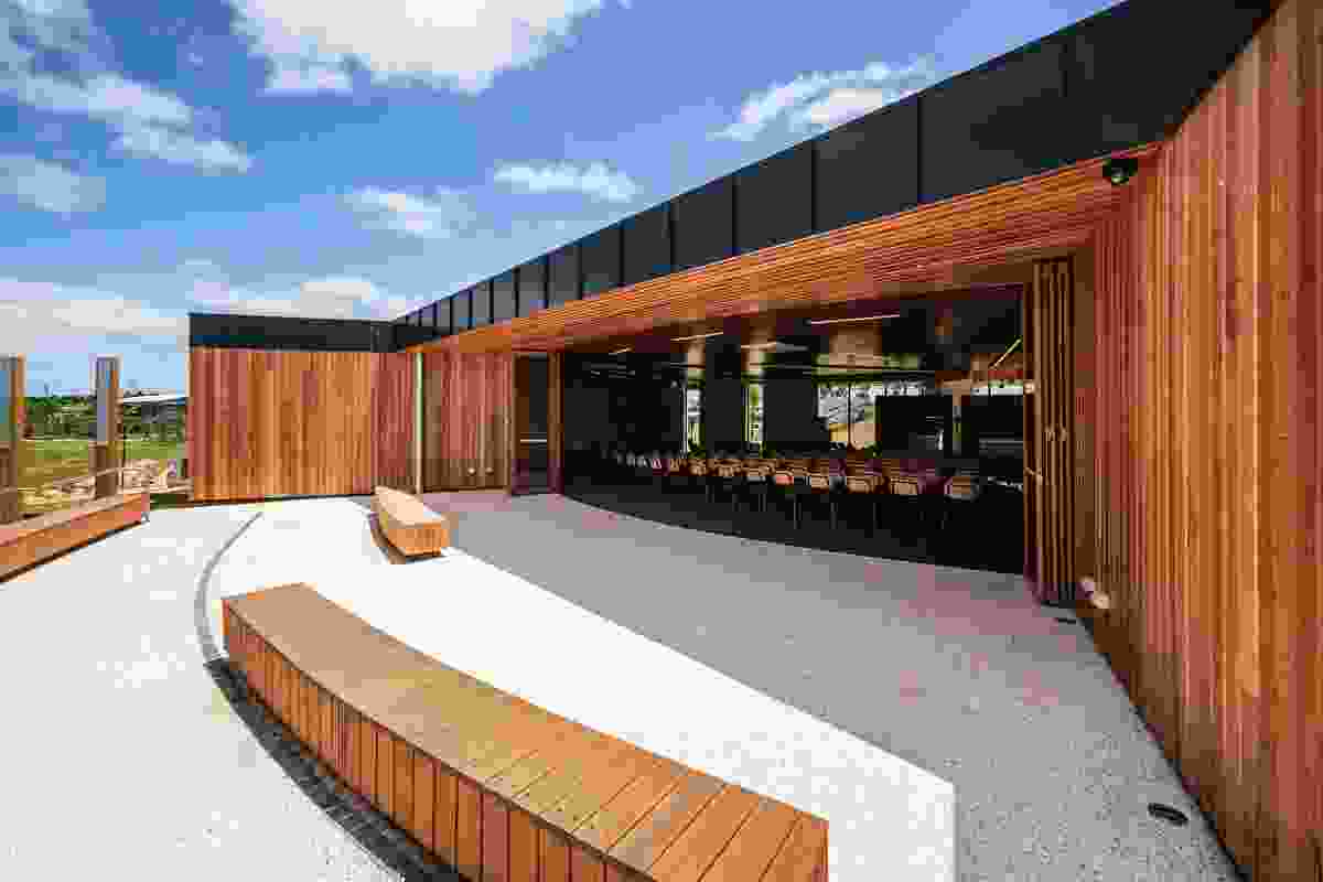 Bifold doors enable the interior space to extend out to the courtyard. Timber benches provide overflow seating, or serve as bleachers for games on the basketball courts opposite.