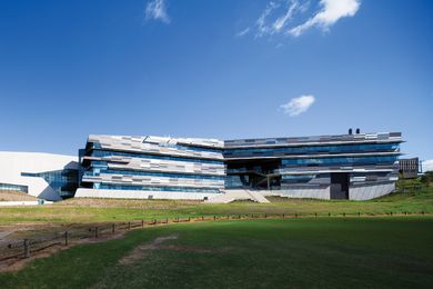 View of the zinc-clad northern facade. The building’s cranked form follows the curve of the ovals below.