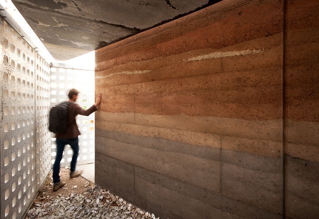 A rammed earth wall in different soil types gives the project a layered, tactile quality. 