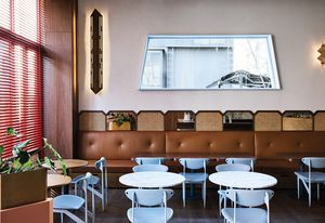 Brass accents, buttery caramel leather banquettes and the use of the Featherston Scape dining chair, an Australian mid-century classic, hint at 1950s Italian spaces.