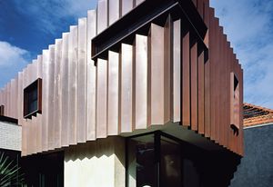 The addition’s pleated copper facade complements the tones of the existing red brick Federation house.
