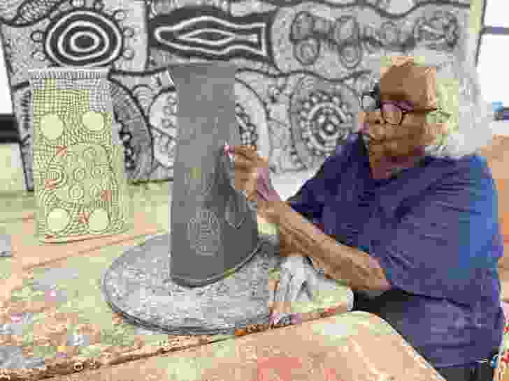 Tjunkaya Tapaya applying sgraffito techniques in the ceramics studio.