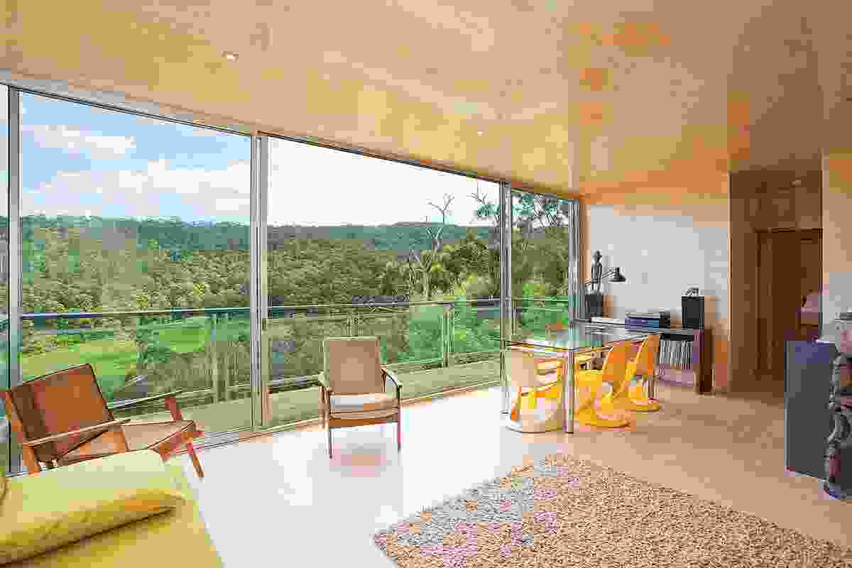 The living area is privy to a distant view framed by a canopy of gum trees.