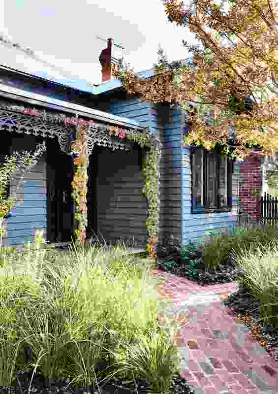 The front facade of the original house was repainted in a dark grey palette to provide a backdrop to the luscious garden.