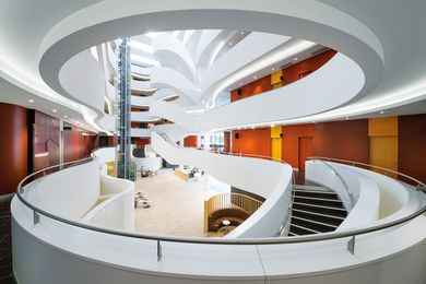 The grand six-storey atrium carves out a glowing white canyon in the centre of the building.