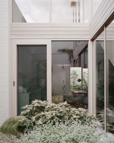 Built to the site’s boundaries, the house steps around two courtyards.