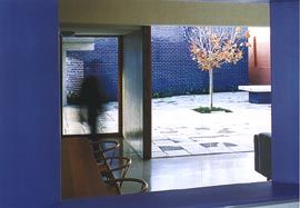 Looking from the kitchen, across the living areas into the main courtyard, with the blue glazed forms of the flat beyond.