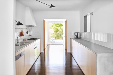 Located at the centre of the plan, a galley kitchen is an occupied threshold that connects the front and back of the house.
