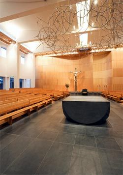 View along the length of the new cathedral, with stone altar and cathedra by Anne Ferguson, aureole by Robin Blau and pews by Kevin Perkins.