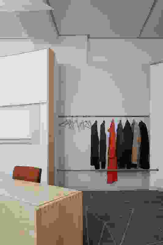 A life-sized photograph of coats hanging on a rack gives the space a sense of occupation.