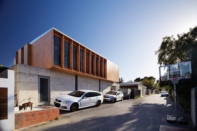 To the street, Lake House takes the form of a timber box elevated on stabilizing rammed-concrete walls.