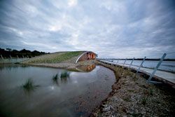 The turf-roofed
centre rising out of its own wetland system, with Swan
Bay beyond.