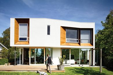 A two-storey extension at the rear of the site adds a solid, weatherboard form hovering above a level of full-height glazing.