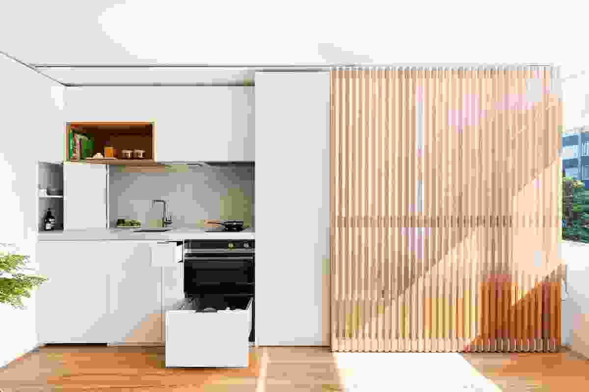 A sliding timber screen in Boneca Apartment (2017) conceals sleeping or cooking zones with one simple gesture.