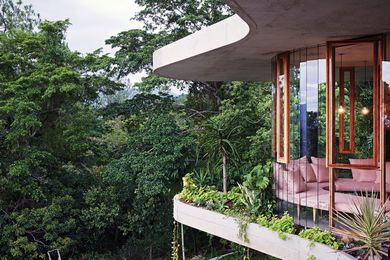 The form of the house is created by two curving concrete slabs (which overlap but aren’t the same shape) with glass in between.