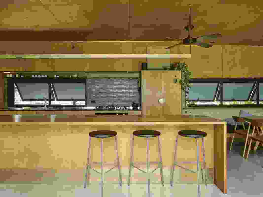 Practical without sacrificing personality, the kitchen includes a finger-tile splashback and custom brass handles. Artwork: Willy Tjungurrayi.