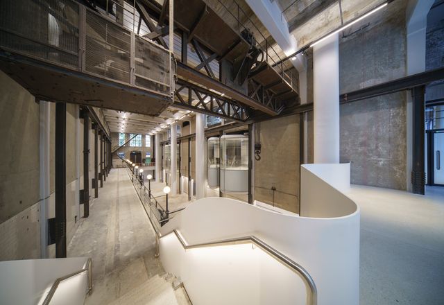 The two-storey machine hall has been preserved as an open gallery space, with new bay windows cantilevering out between the heritage steel detailing.