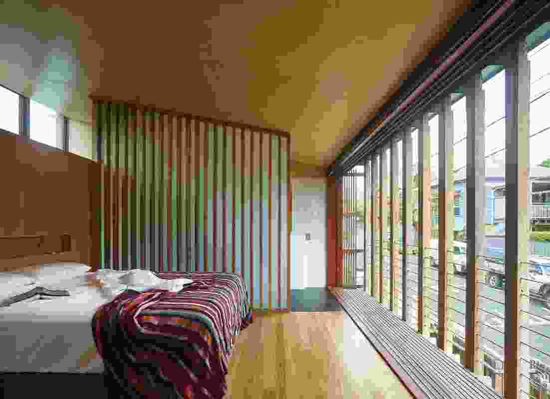 The main bedroom overlooks the street and an outer skin of striated timber encages a narrow strip of balcony.