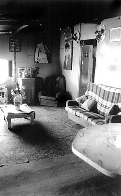 The interior of Clem and Isabel’s “living room” was lined with masonite painted sky blue. The floor was a concrete slab flush with the outside and covered with pieces of carpet. A lot of care was taken to keep the room tidy, with the floor swept with a prized stiff broom every day. Elvis music and country and western movies featured strongly in their day-to-day lives and many favourite items are on display. This room is right next to the front door and was occupied as a living and sleeping space depending on the number of inhabitants.