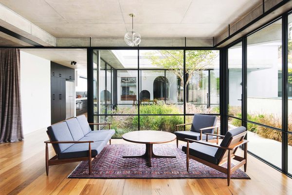 A courtyard erupting with billowing grasses draws in light and offers views through the living room to the dining area.
