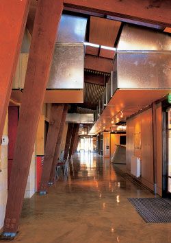 View along the public circulation spine. The building is detailed so that functional elements also have spatial and decorative effect. Here the roof cooling system extends into and articulates interior space.