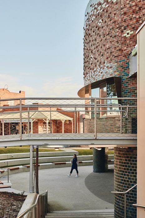 A small bridge hovering above an amphitheatre designed to accommodate the site’s contours leads to the main entrance.