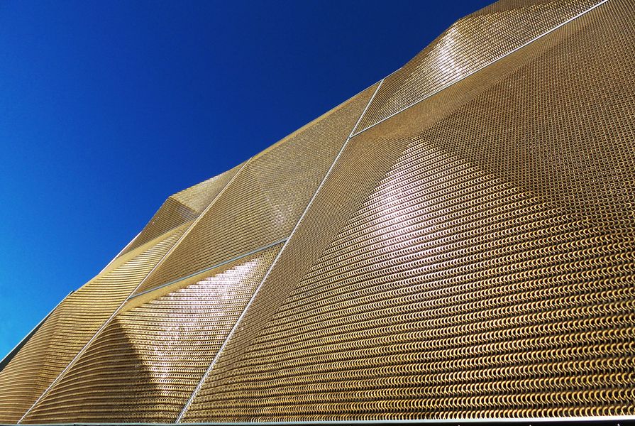 Bronze pyramids to the facade screen glow in direct sunlight: the mesh provides good visibility to those working inside.