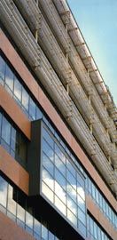 Detail of the east elevation, showing the screening to the upper level inpatient floors and an oriel window punching through from the diagnostic and treatment levels below.