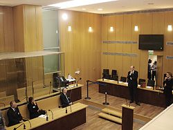 The terrorism court (2005), in the wing of the Palais de Justice, Paris. Note the glazed dock for multiple defendants. The defence lawyers sit directly in front of the dock and the sliding glass panels facilitate interaction between the defendants and their advocates. Photograph taken by Diane Jones during the Court of the Future executive research seminar, Paris, September 2005.
