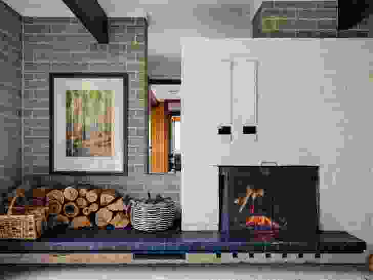 A brick fireplace marks out space for a second living room, a retreat from the central family spaces. Artwork: Arnold Jarvis.