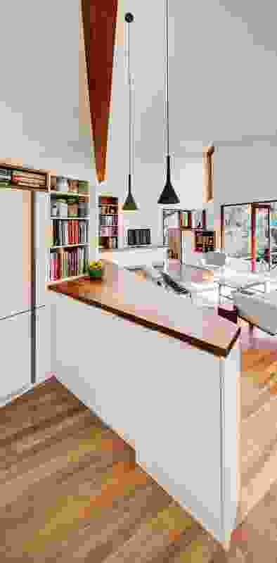 The flat ceiling over the kitchen benchtop rises to a much higher vaulted ceiling over the living space.