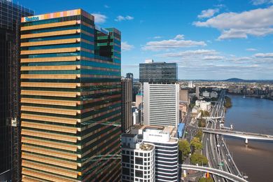 The flat, pixel-like colour blocks of the southern facade contrast with the patterned, folded metal shades of the western facade.