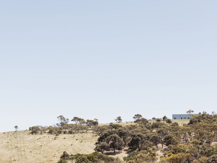 The house creates a striking rectangular silhouette against the backdrop of sky and sea.