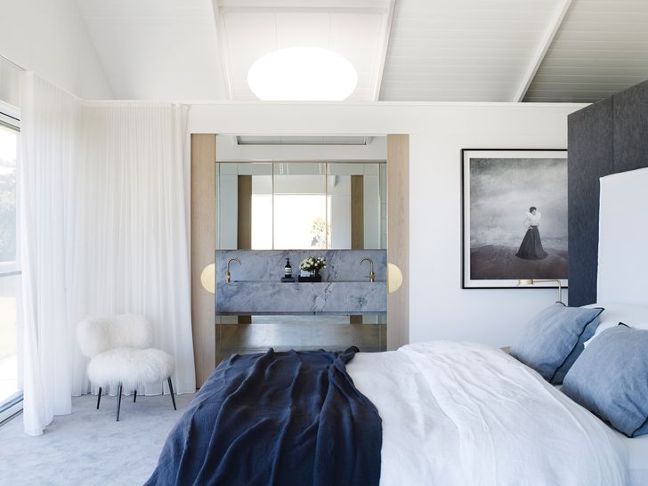 Large sliding doors connect the main bedroom to the ensuite, with sheer curtains for a softer enclosure. Artwork: Michael Cook.