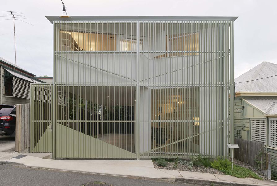 The house adopts the form and scale of neighbouring homes, but is set apart by details such as the aluminium screen.