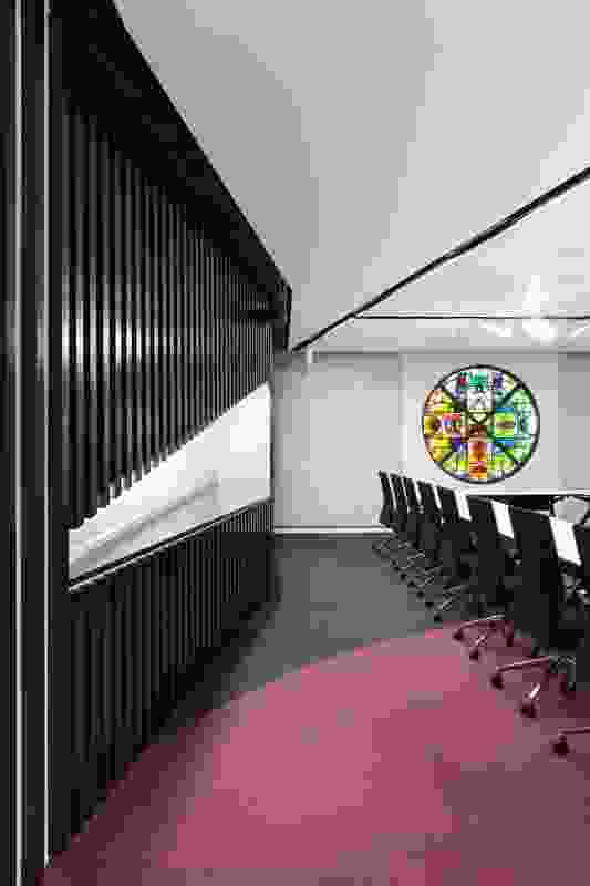 A stained glasswork by Leonard French hangs in the boardroom. The glasswork informed the colour of the carpet chosen for the boardroom.