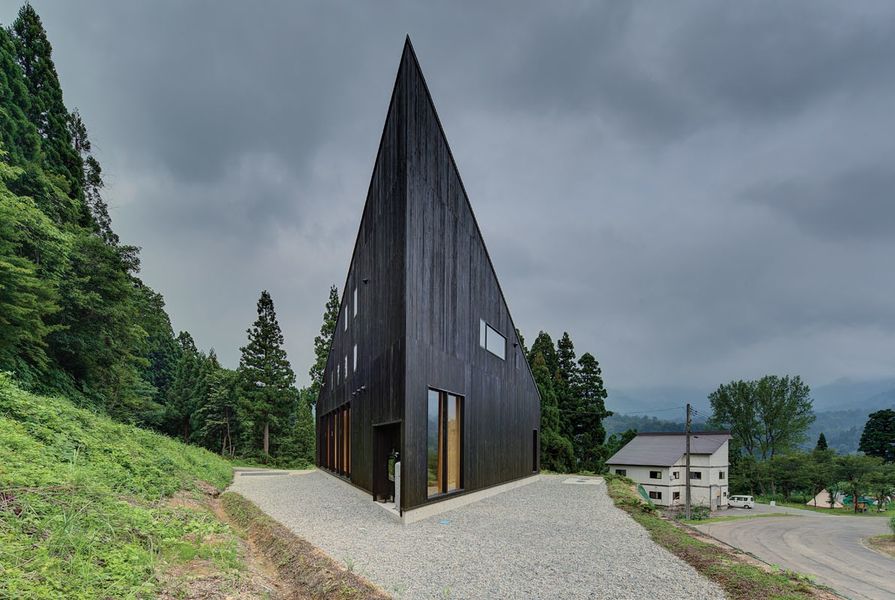 The dark, striking roof form serves a snow-shedding function.