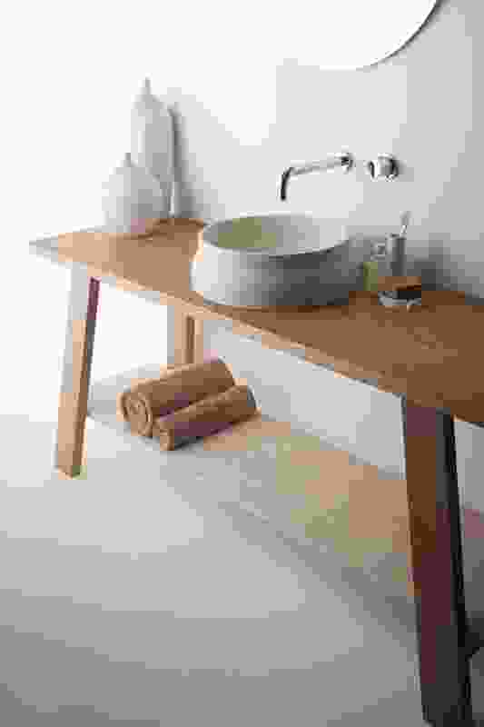 Designed for Omvivo, the Latis Basin is made of natural stone and is seen here with the Latis Trestle Table in American oak.