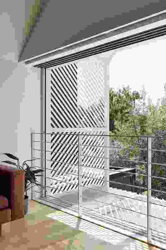 On the first floor, an exterior aluminium screen frames the view and filters northern sun.