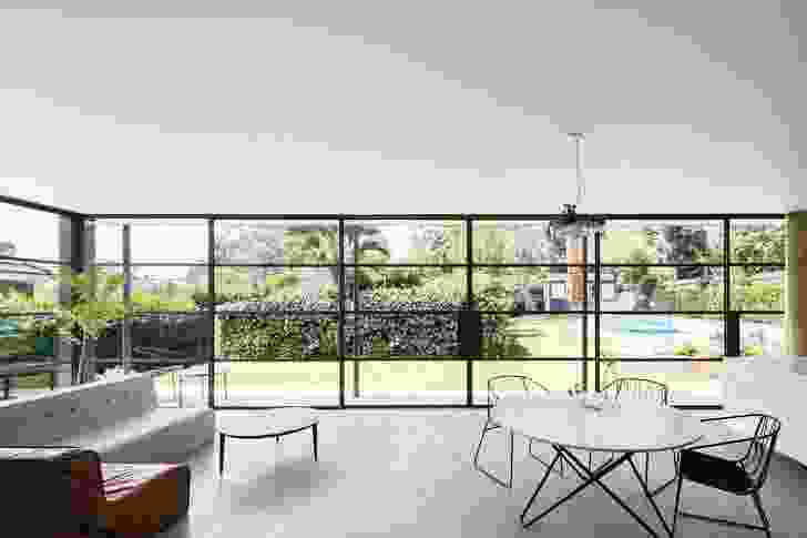 The kitchen, dining and living room look out to the garden through glass walls and sliding doors framed in fine steel.