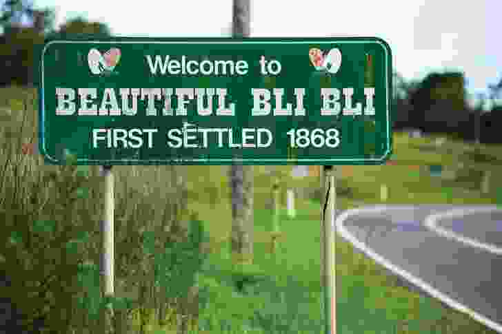 The town sign for Bli Bli on Queensland’s Sunshine Coast welcomes visitors to “Beautiful Bli Bli, first settled 1868,” in a message ornamented with butterflies.