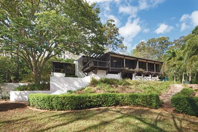 When viewed from the garden terraces below, the house presents itself as a framed box propped off its brick piers and retaining walls, which extend into the garden.