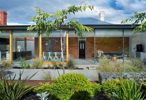 Looking at the extension of Jenny’s House from the garden, the roof appears as “a thin plate resting lightly on tiled bookends.”